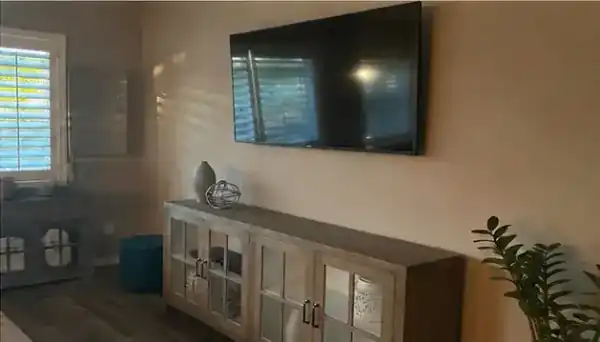 Mounted television centered above a living room media console