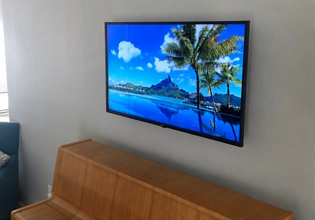 Wall-mounted TV centered above a piano